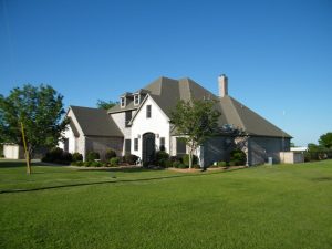 Brick home, blue sky, green lawn — Tips to Sell My Home Quickly for Cash