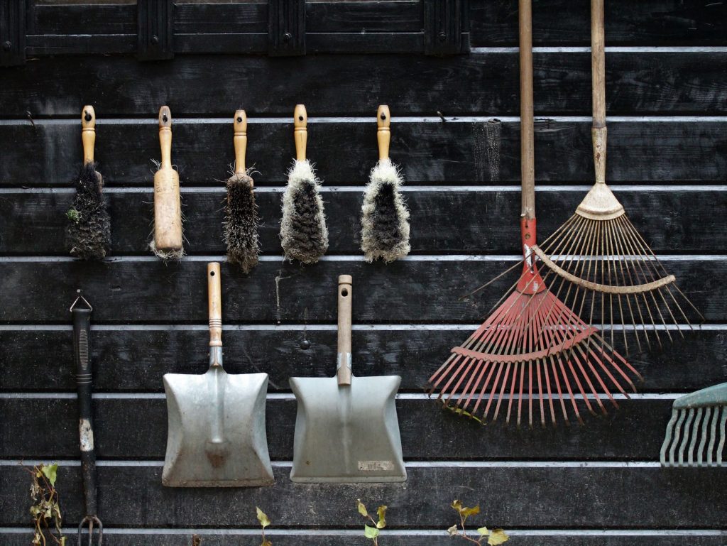 Neatly arranged garden tools hanging on a rustic wooden wall. — Using Pavestones inside your Landscaping to produce a Decorat